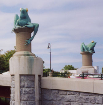 Two frogs atop thread spools